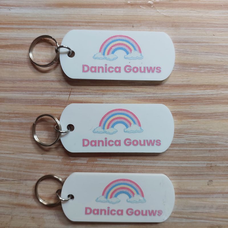 White Perspex bag tags with a rainbow
